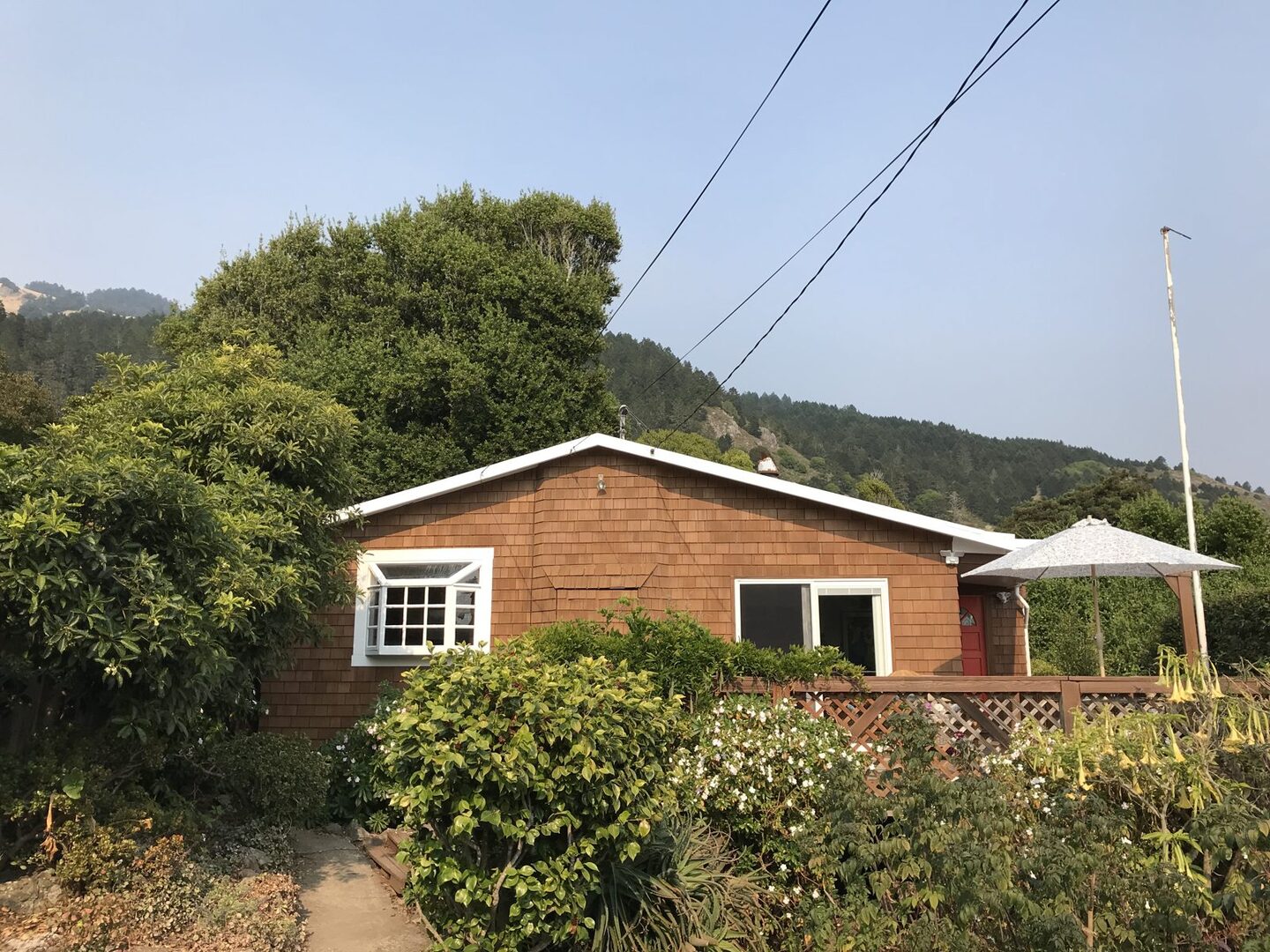 Cottage exterior with bay window and garden in evening light