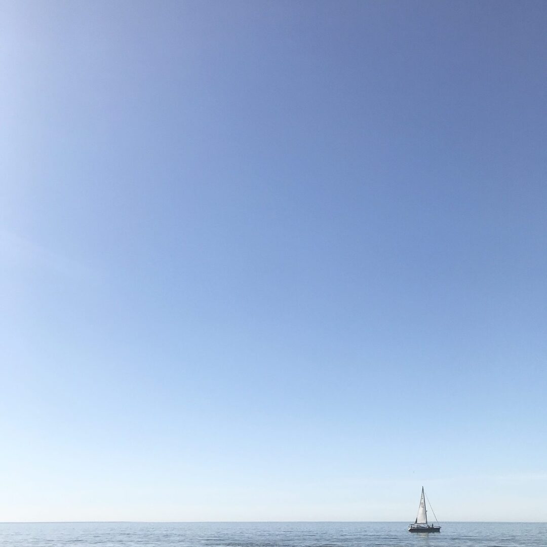 A lone sailboat on calm water