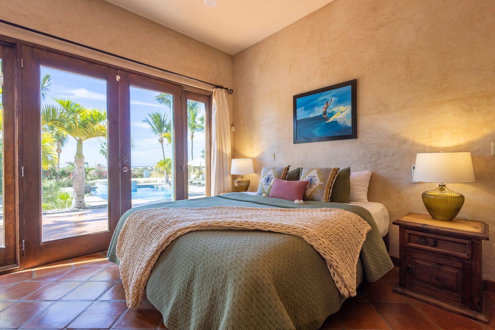 Bedroom with French doors opening to pool and palms