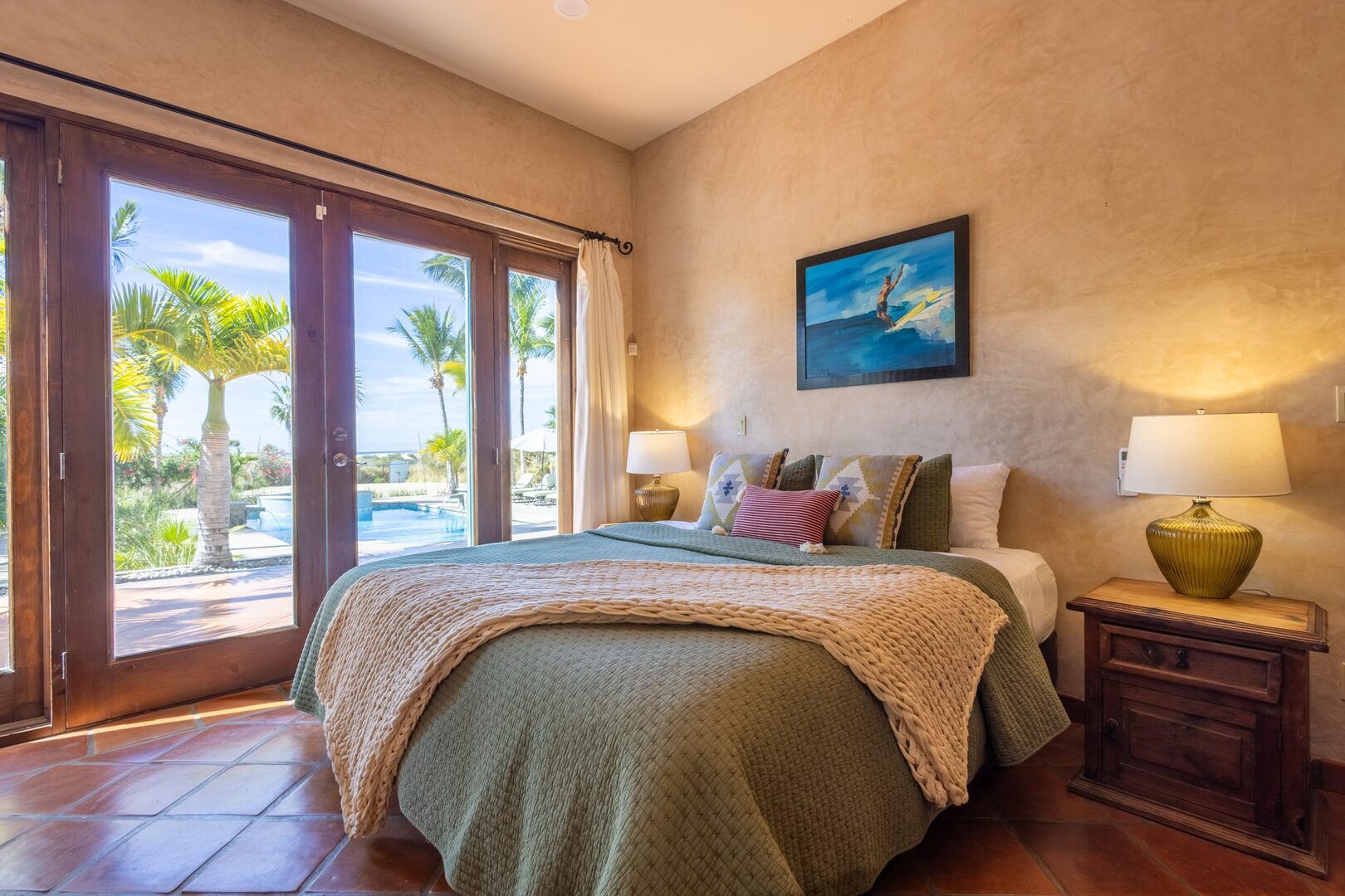 Bedroom with French doors opening to the pool and palms