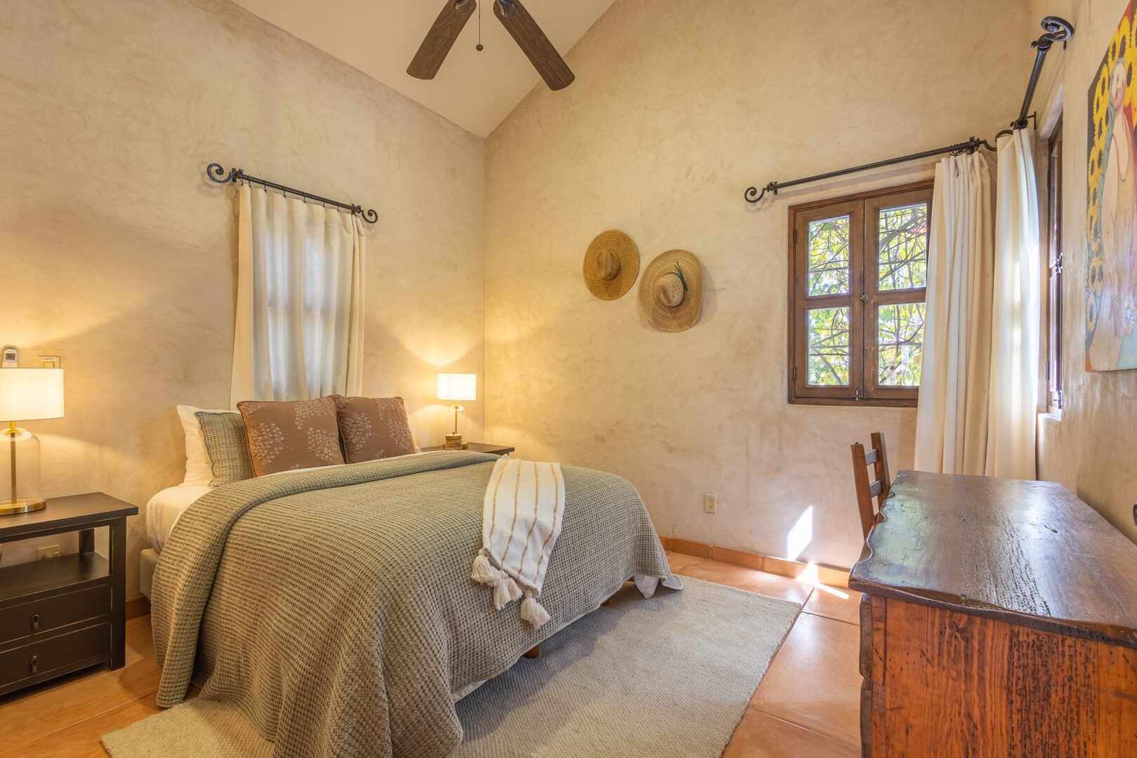 Bedroom with sage green linens and rustic dresser