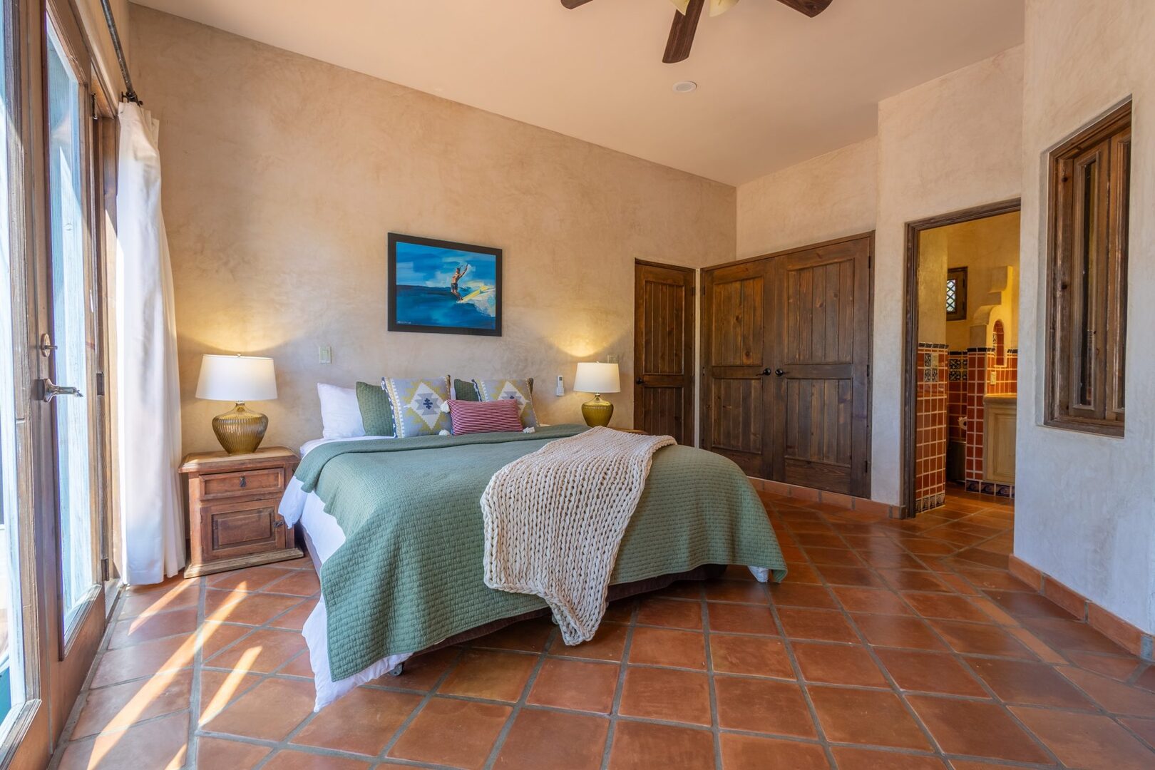 Master bedroom with terracotta floors and en-suite bathroom