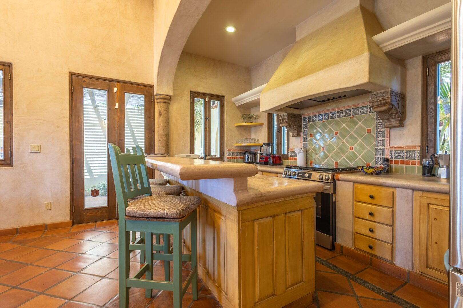 Kitchen with stone hood and tiled backsplash