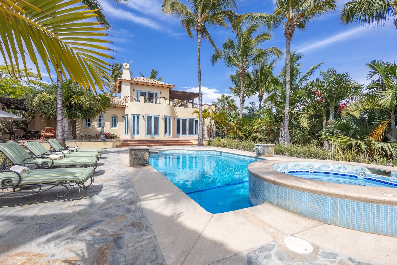 Pool and hot tub with flagstone surround and loungers