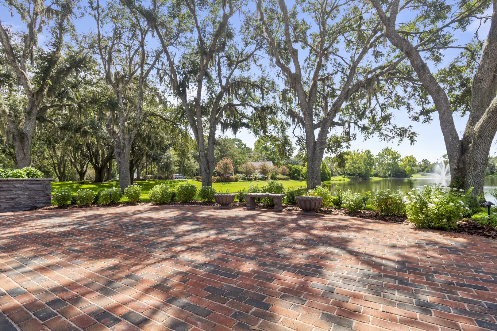 Brick patio beneath oak trees overlooking the lake