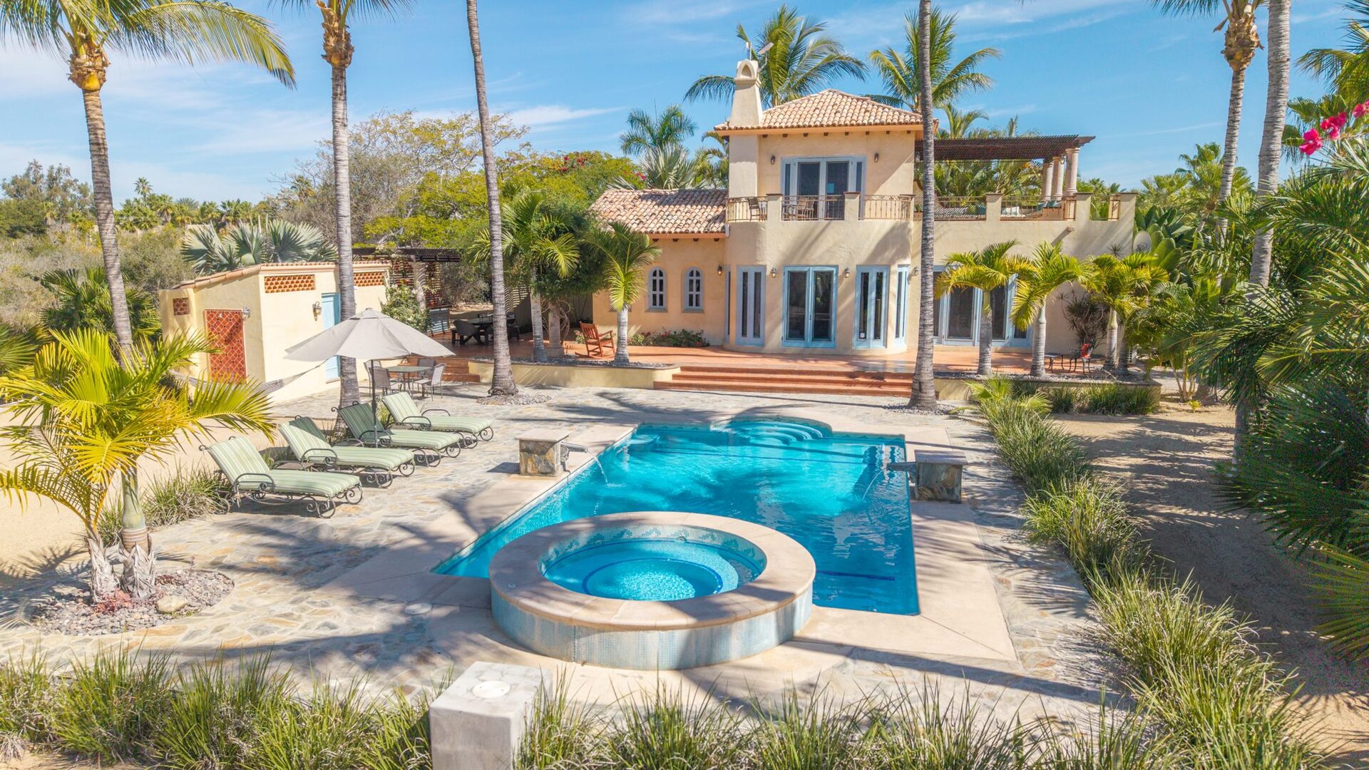 Elevated view of the pool, hot tub, and main house from above