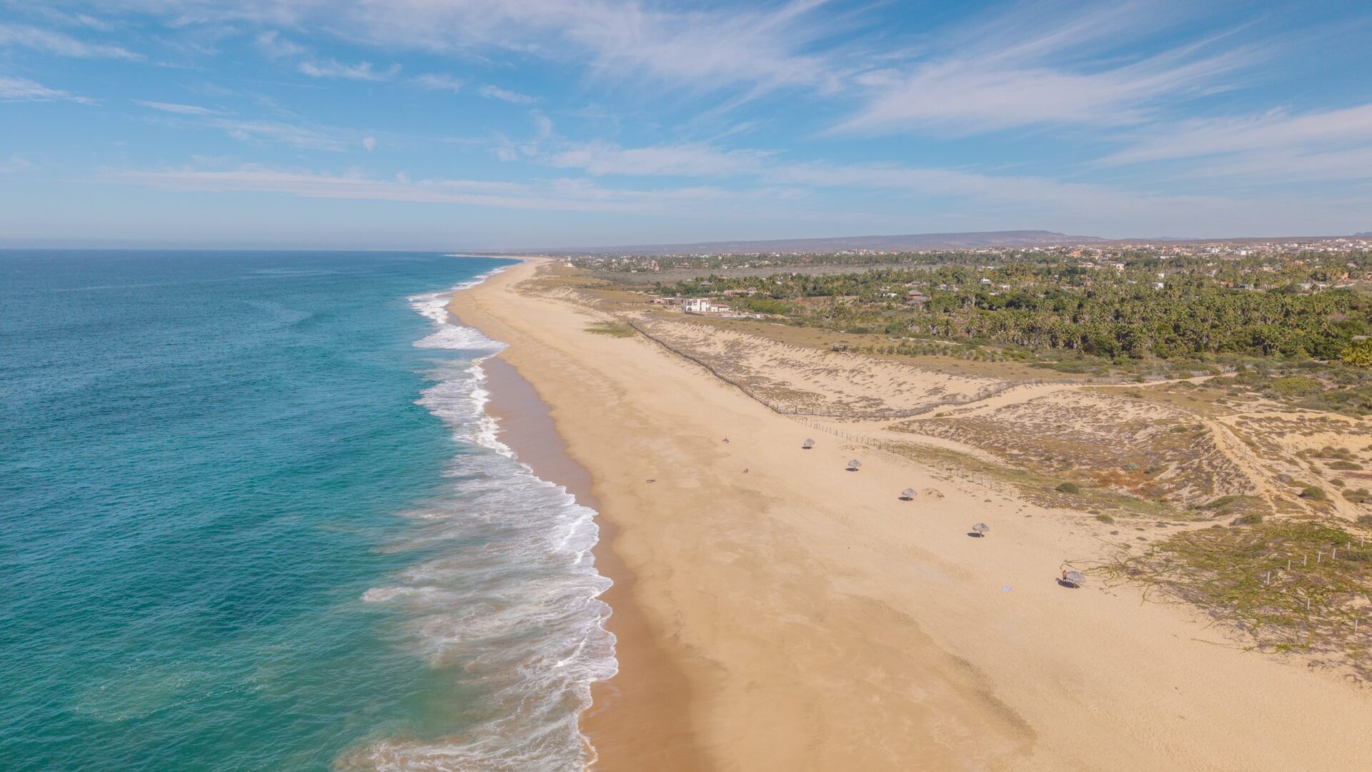 Aerial view of waves rolling onto the sandy shore